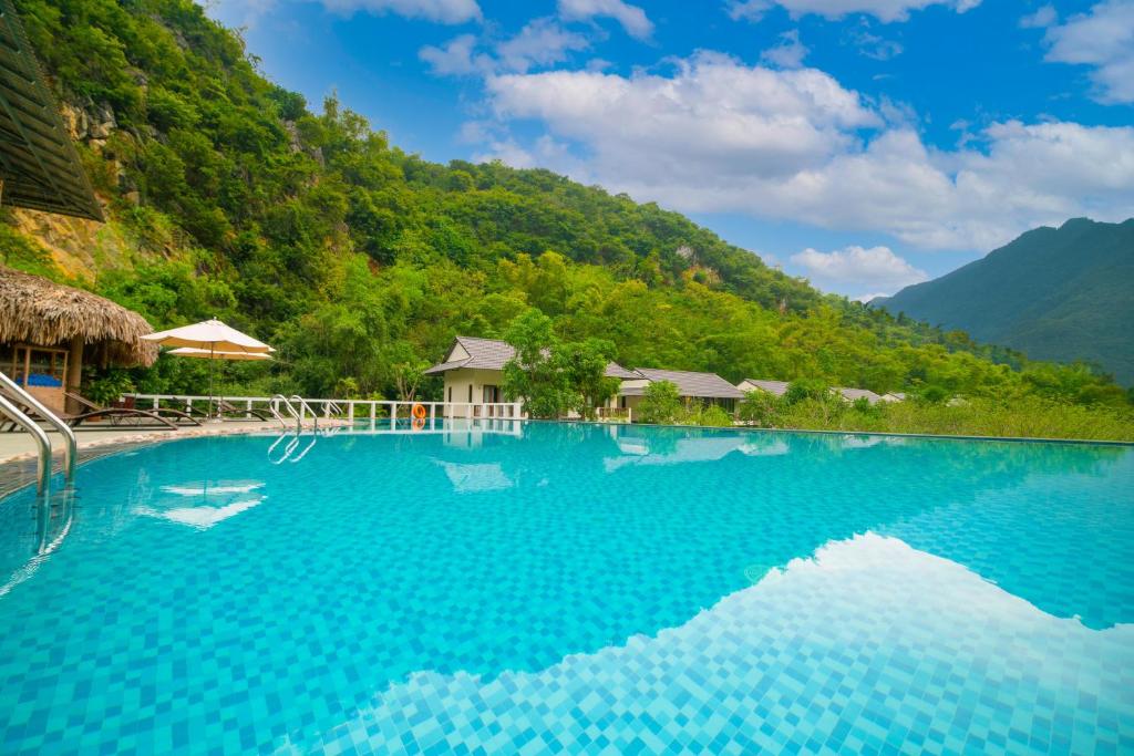 a swimming pool with mountains in the background at Mai Chau Mountain View Resort in Mai Chau