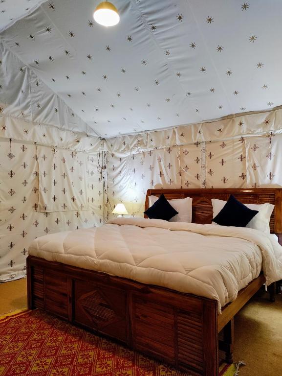 a bedroom with a large bed in a tent at Omya Forest Camps & Cottages Bir, Near Choti Machiyal in Bīr