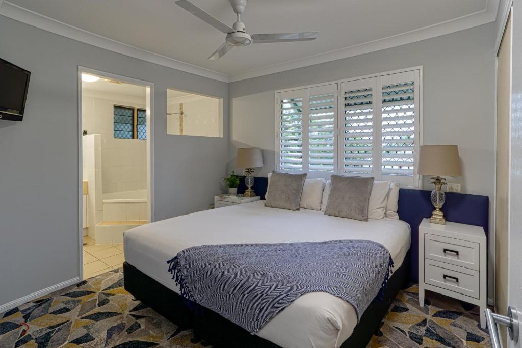 a bedroom with a large bed and a bathroom at Townsville Southbank Apartments in Townsville
