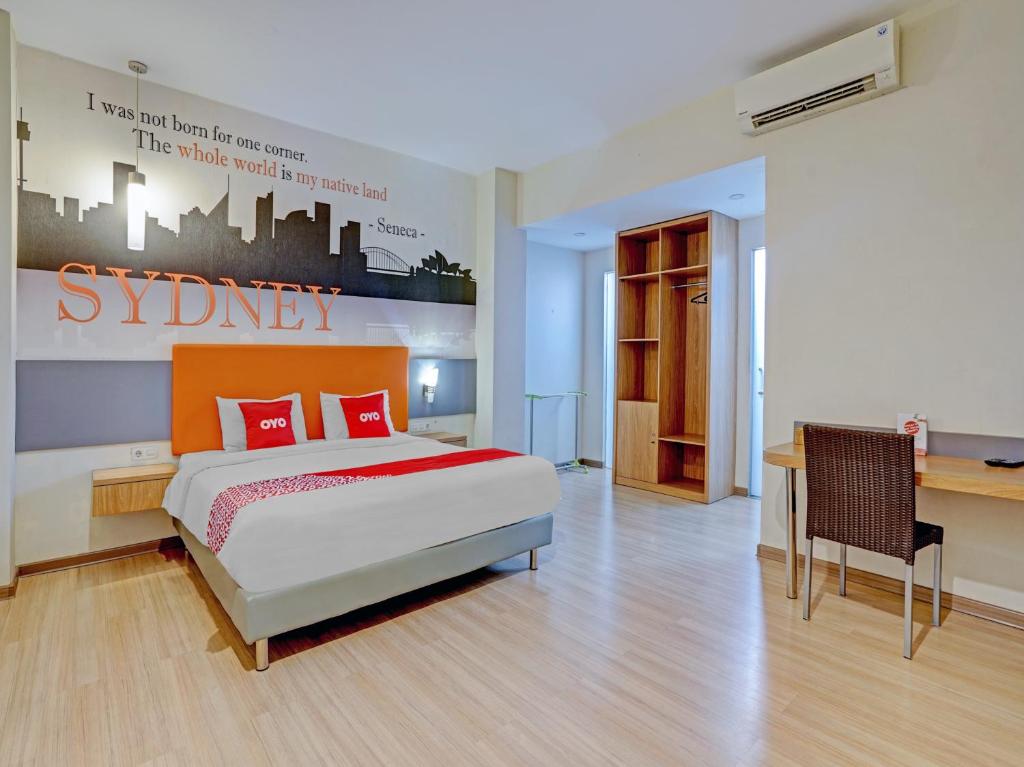 1 dormitorio con cama y escritorio en Super OYO Capital O 3905 Graha 100 Guest House Syariah, en Surabaya