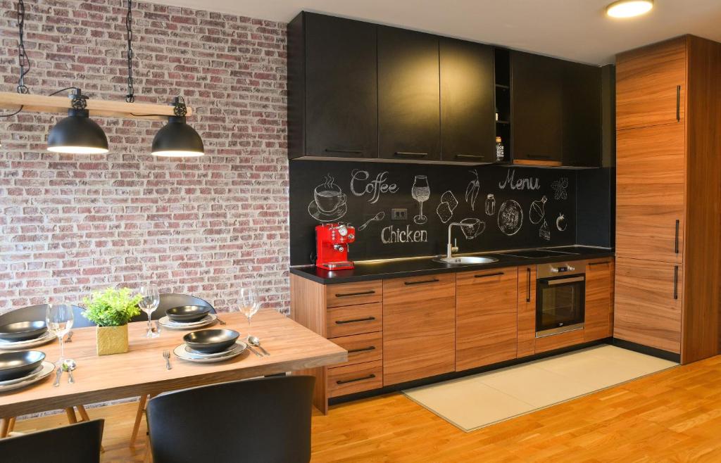 a kitchen with wooden cabinets and a brick wall at Apartments at Ljubovic Hill Park in Podgorica