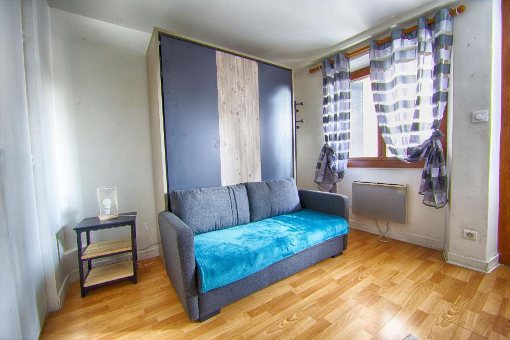 een woonkamer met een blauwe bank in een kamer bij Petit T1 à proximité des thermes in Aix-les-Bains