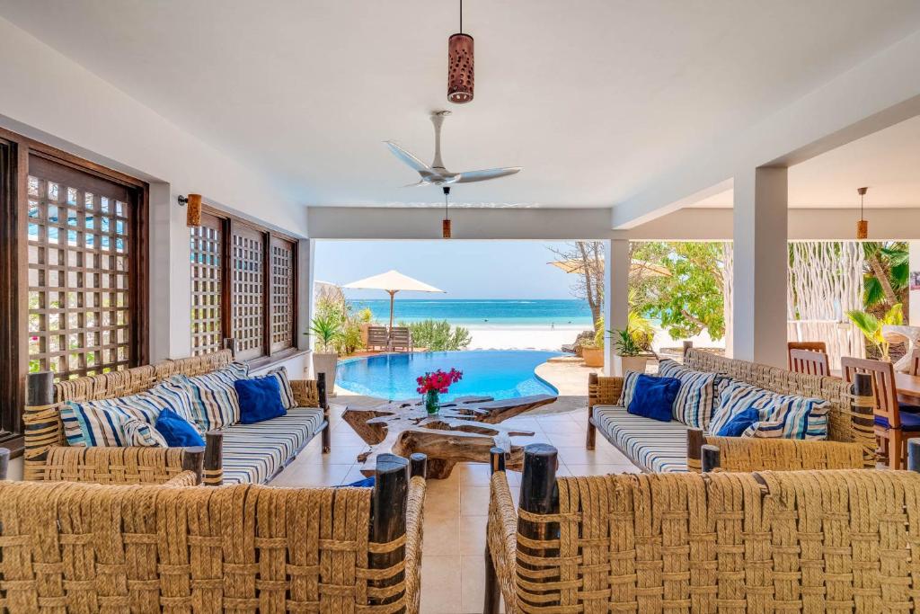 sala de estar de planta abierta con sofás y piscina en Tequila Sunrise Pool Cabana-Diani Beach, en Diani Beach