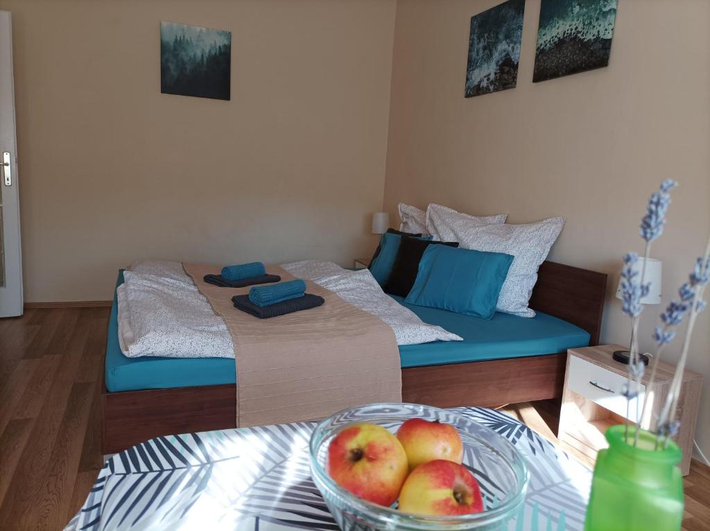 um quarto com uma cama e uma tigela de fruta numa mesa em Zöld Apartman em Miskolc