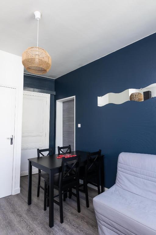 a dining room with a black table and chairs at Au nid douillet - Dormir Comme A La Maison in Châteaubriant