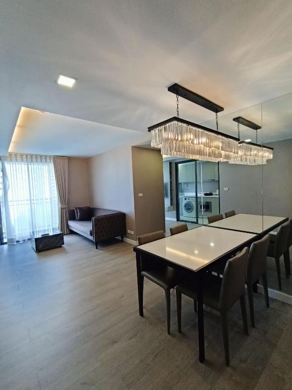 a dining room and living room with a table and chairs at 18 Residence in Bangkok