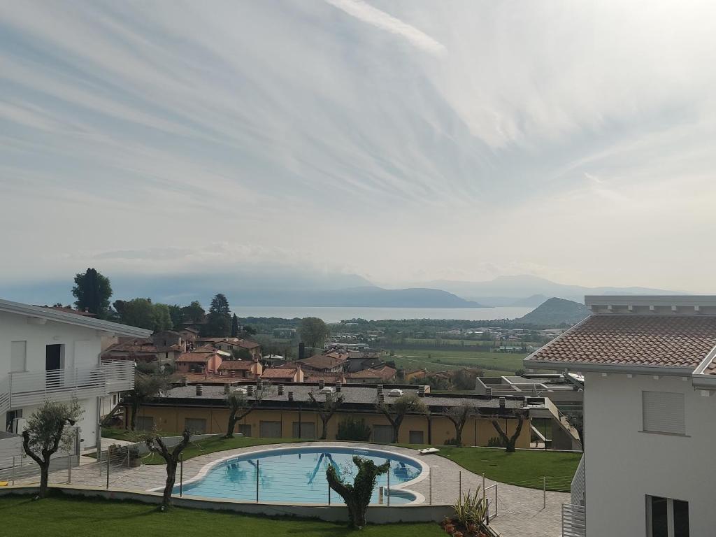 - Vistas a una casa y a la piscina en Bilocale in residence vista lago con piscina, en Polpenazze del Garda