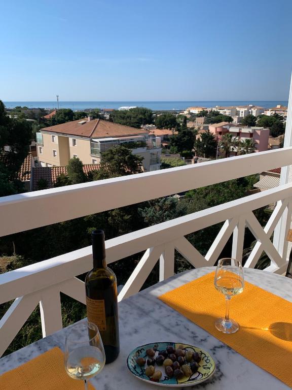- une bouteille de vin et une assiette de nourriture sur une table dans l'établissement studio mezzanine - vue mer - terrasse - parking - literie neuve !, à Sète