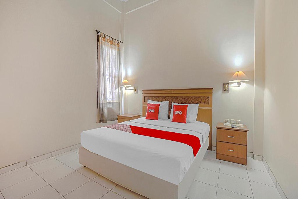 sypialnia z dużym łóżkiem z czerwonymi poduszkami w obiekcie Collection O 90589 Palem Garden Hotel w mieście Tulungagung