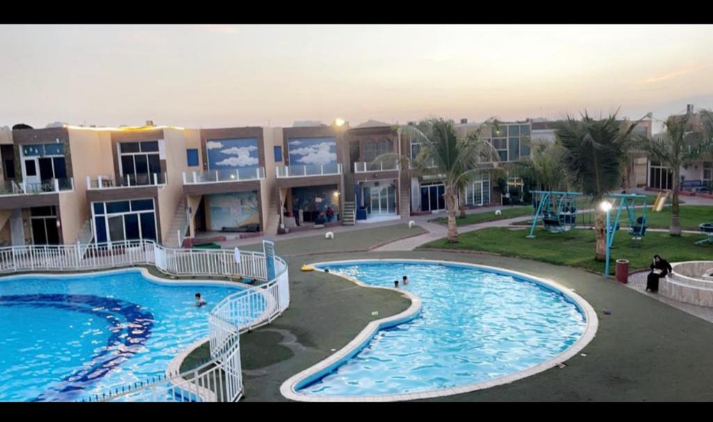 a large apartment complex with two swimming pools at شاليه جزيره السعاده in Obhor
