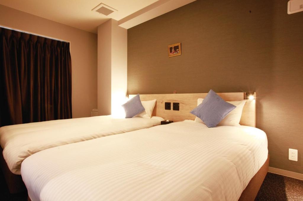 Postel nebo postele na pokoji v ubytování HOTEL STATE TENNOJI