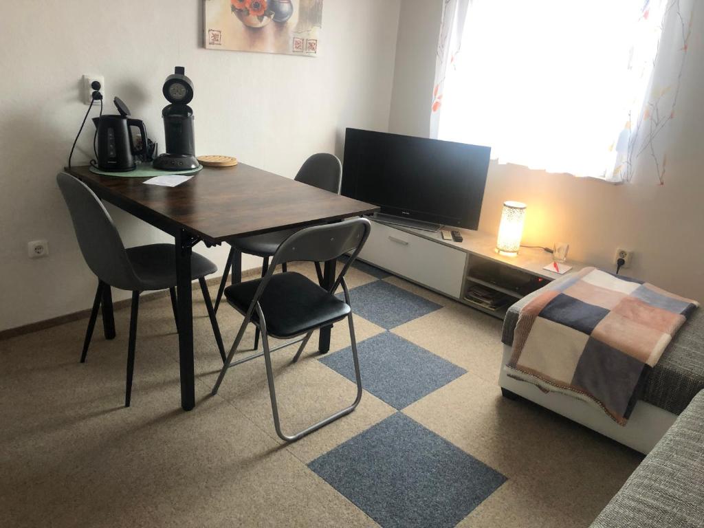 um quarto com uma mesa e cadeiras e uma televisão em Scharfs Kämmerla em Baiersdorf