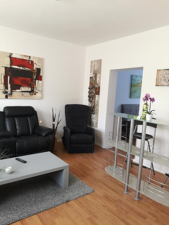 sala de estar con sofá negro y mesa en Havelberg Ferien Apartments HCR, en Havelberg