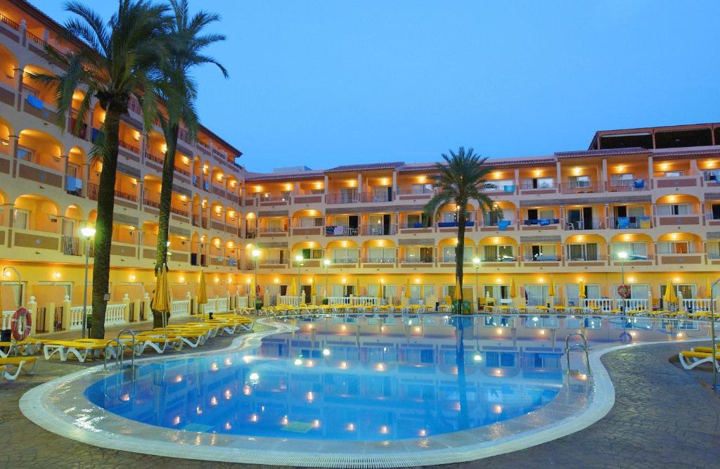 um hotel com uma grande piscina em frente a um edifício em Bahía Tropical em Almuñécar
