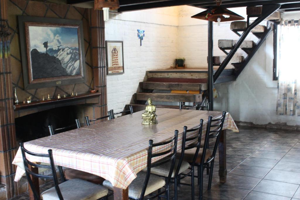 a dining room with a table and chairs and stairs at Samadi Hostel Uspallata in Uspallata
