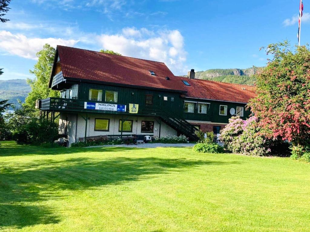 a large house with a green lawn in front of it at Hjelmeland Camping & Hostel Nøkling in Hjelmeland