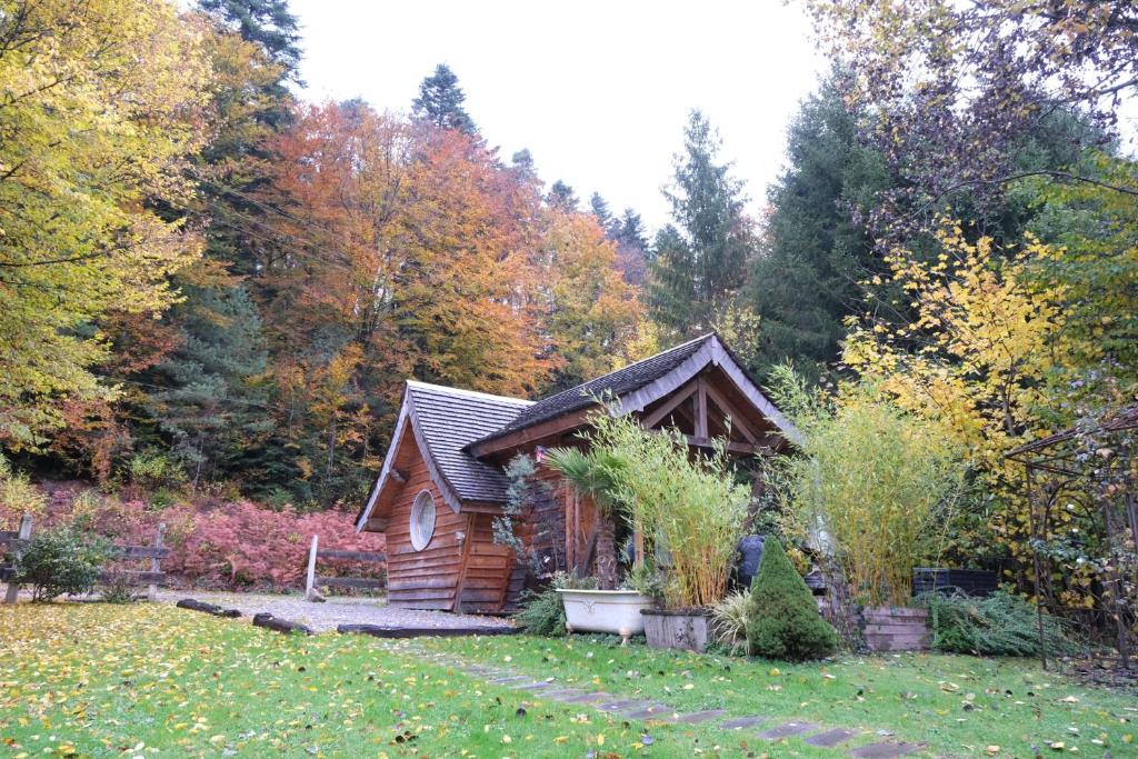 une cabane en rondins au milieu d'une cour dans l'établissement Charmant chalet aux portes d'Epinal, à Épinal