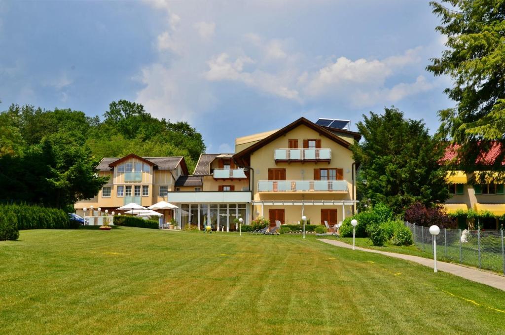 a large house with a lawn in front of it at Seehotel Paulitsch in Velden am Wörthersee
