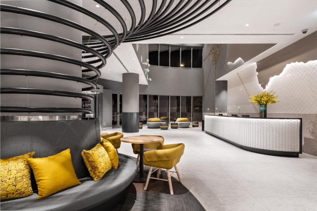 A contemporary lobby combines a curved sofa lounge with a bright reception desk.