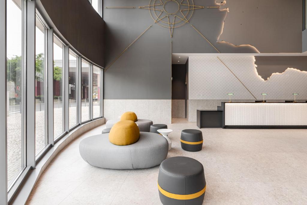A bright lobby lounge with sculptural seating beside tall windows.