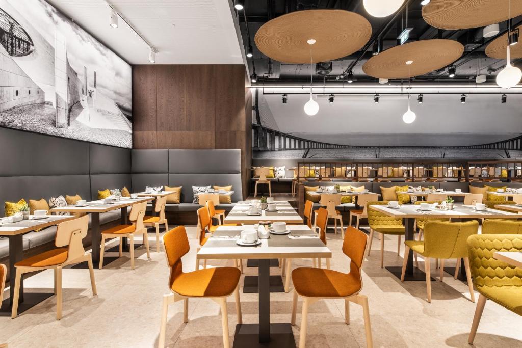 A large, brightly styled dining room with set tables, booth seating, and a visible buffet.