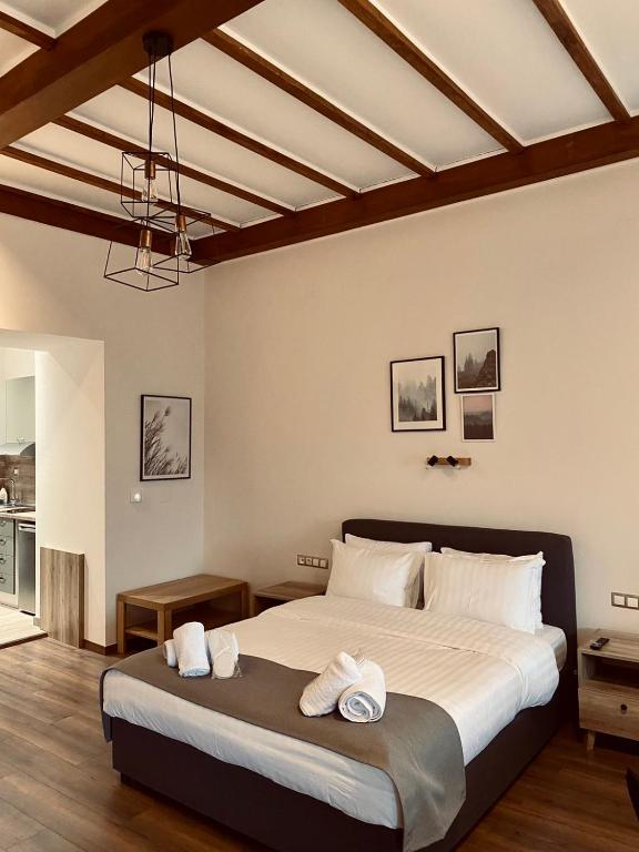 - une chambre avec un grand lit et 2 serviettes dans l'établissement 11 Luxury Apartments Metsovo, à Metsovo
