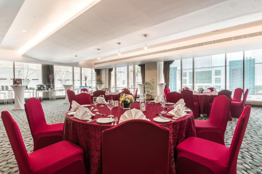 una sala conferenze con tavoli, sedie rosse e finestre di Radisson Blu Hotel, Doha a Doha