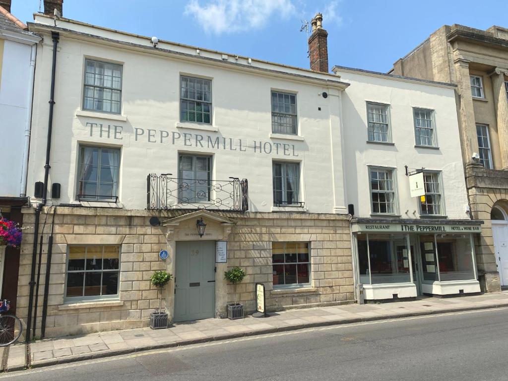 a large white building on the corner of a street at The Peppermill Town house Hotel & Restaurant in Devizes
