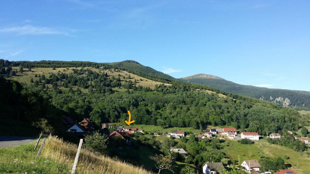 uma pequena aldeia numa colina com montanhas ao fundo em MAISON LUPINS 8 PERSONNES em Geishouse