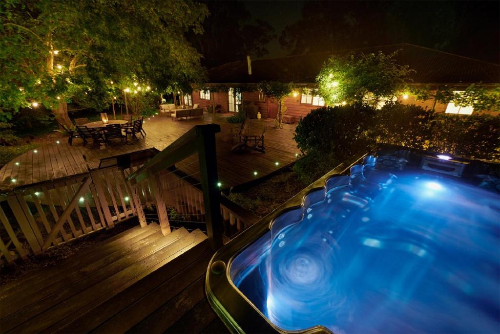 a hot tub on a deck at night at Gumtree Glen in Kangaroo Valley