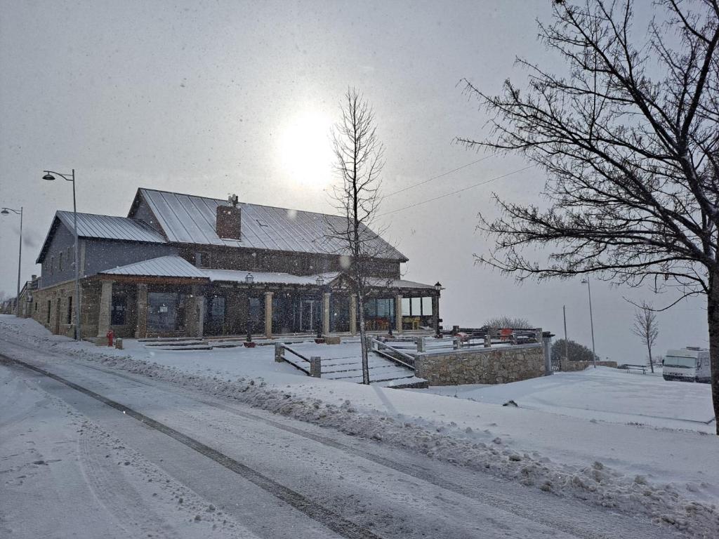 a building on a street with snow on the ground at Alojamento de montanha in Penhas da Saúde