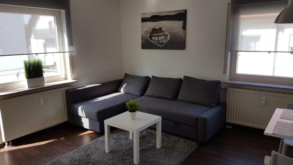 a living room with a couch and a table at Ferien- und Businessapartment I Modern mit WLAN und Parkplatz nahe Zentrum, Automobil- und Tech-Firmen, Messe in Renningen
