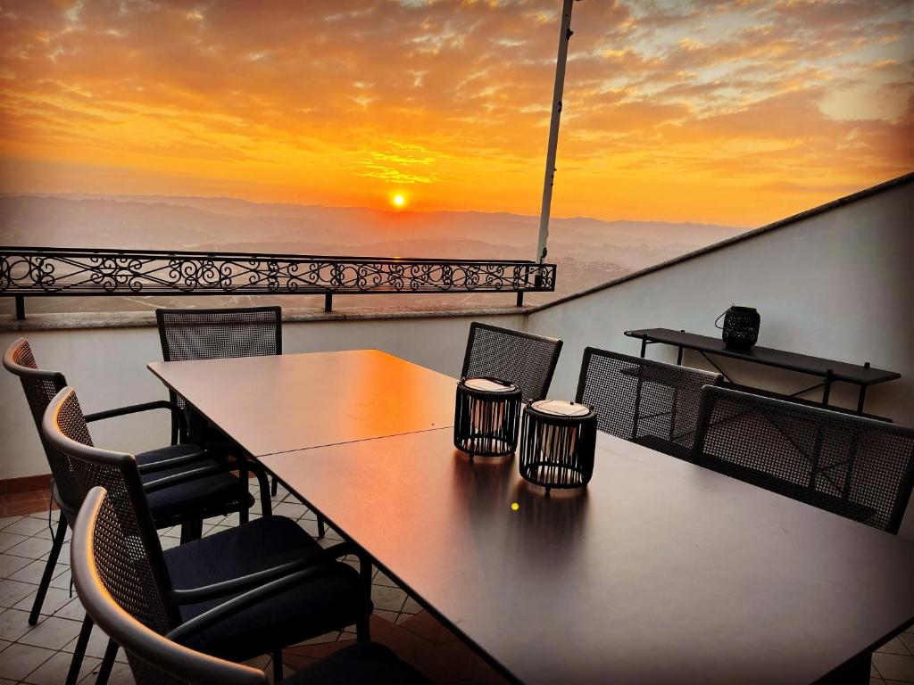 a table and chairs on a balcony with a sunset at La Vista Barolo in La Morra in La Morra