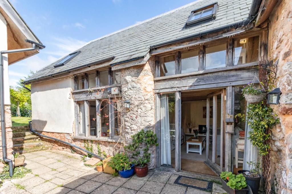 an external view of a stone house with a patio at Pilgrims Rest Cottages, Three Award Winning Characterful Cottages, Sleeping 2-8 People, Parking, Mins From Beach & Countryside Walks in Torquay