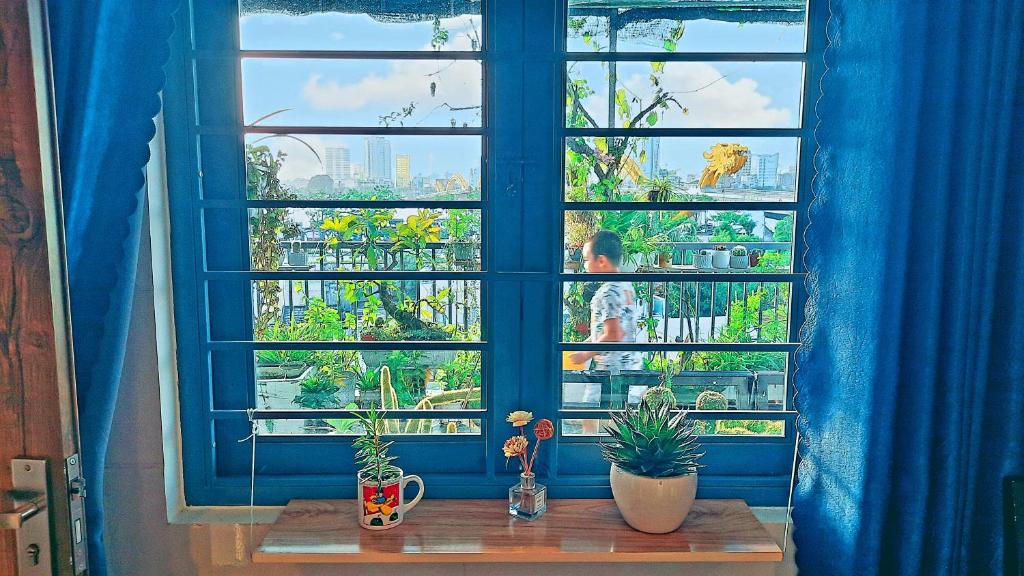 a blue window with plants on a wooden table at Sena home 4th-Rooftop Overlooking Danang Dragon bridge in Da Nang