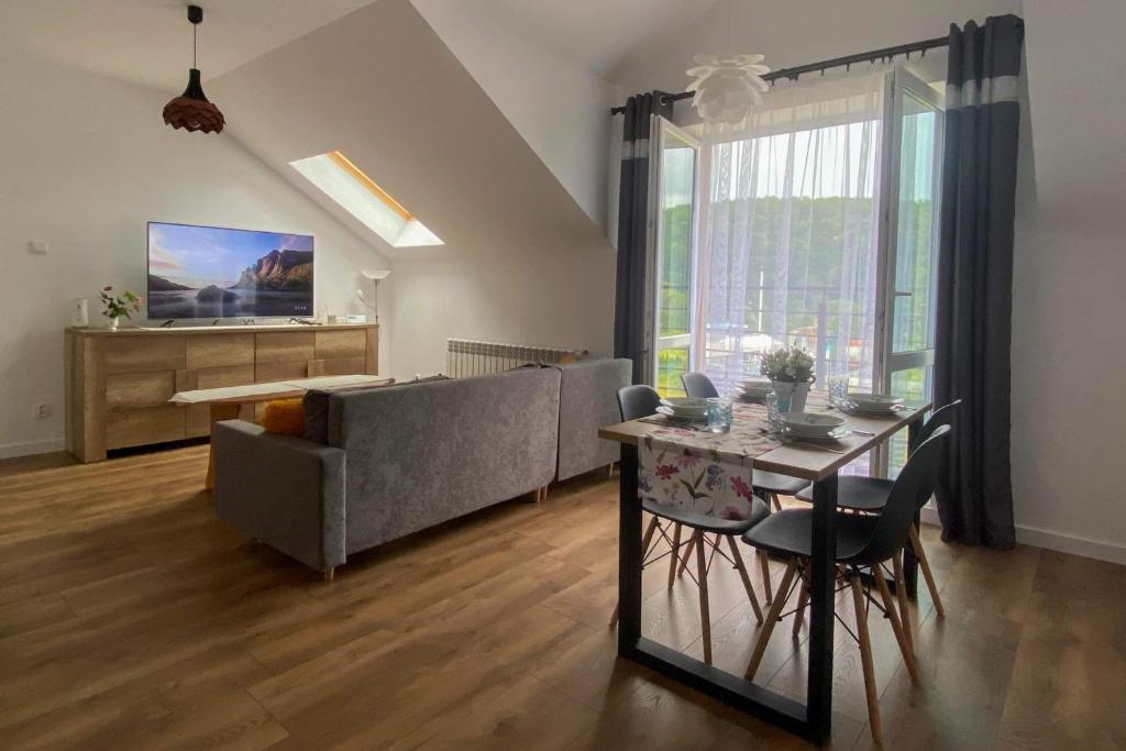 a living room with a couch and a table with chairs at Apartament Bieszczady in Hoczew