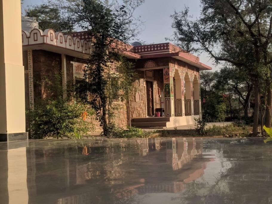 a building with a reflection in a pool of water at Prabhu Niwas Jaipur 45 km on Delhi Road in Jaipur
