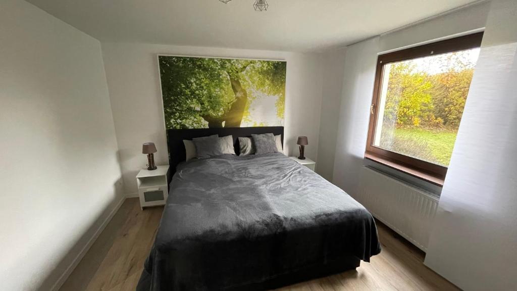 a bedroom with a bed and a large window at Villa Vorkastell in Börfink