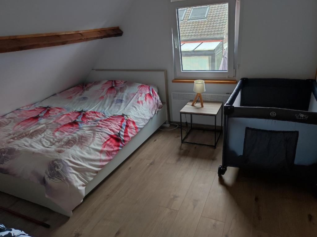 a bedroom with a bed and a table with a lamp at Apartament Beti in Oostkamp