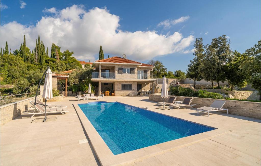 契利比的住宿－Beautiful Apartment In Cilipi With Outdoor Swimming Pool，一座带游泳池和房子的别墅