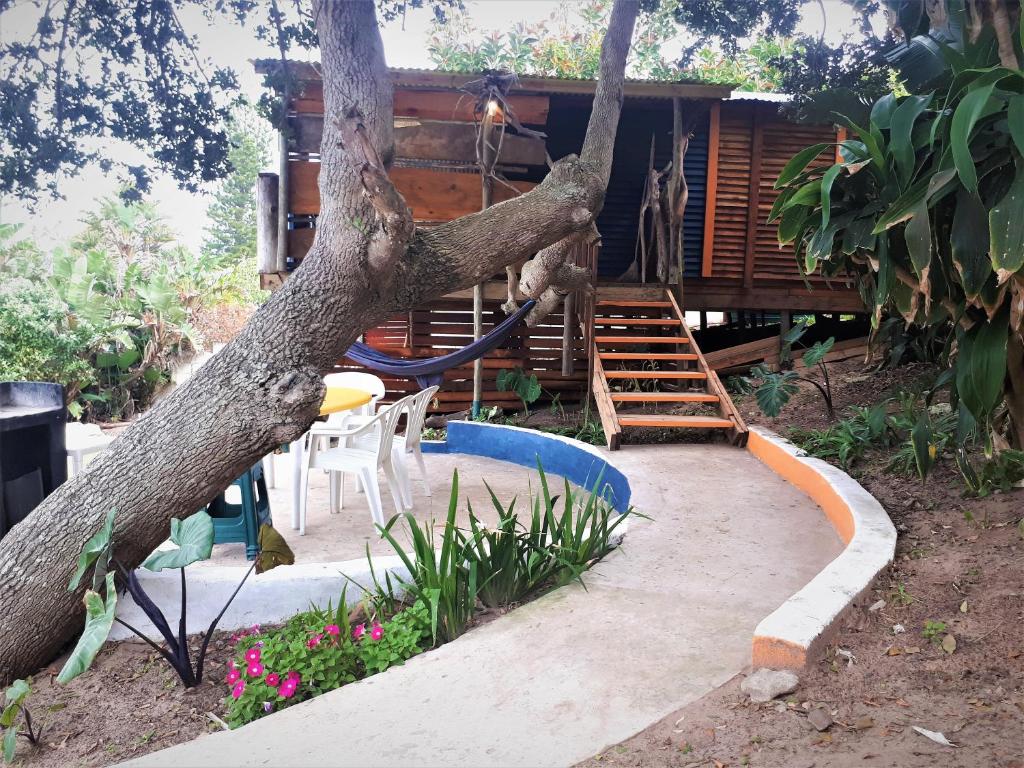 a tree with a playground in front of a house at Blue Space Beach Shack in Hibberdene