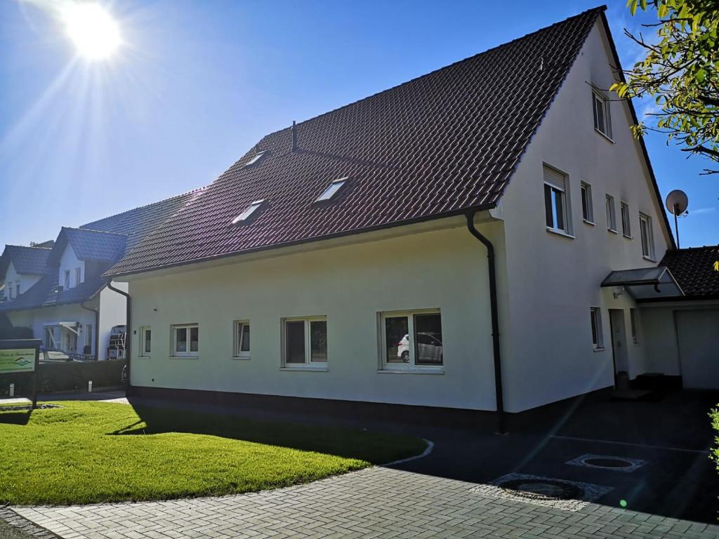 a white house with a brown roof at Pension und Ferienwohnung Walther in Storkow
