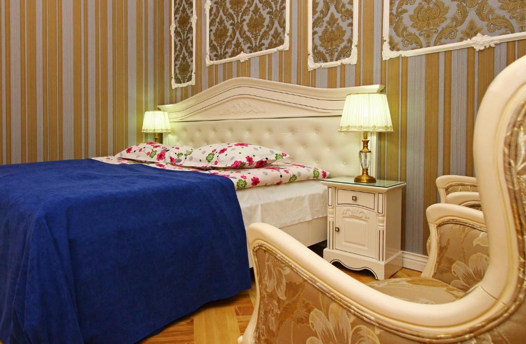 a bedroom with a bed and a chair and a table at Sanata in Tbilisi City