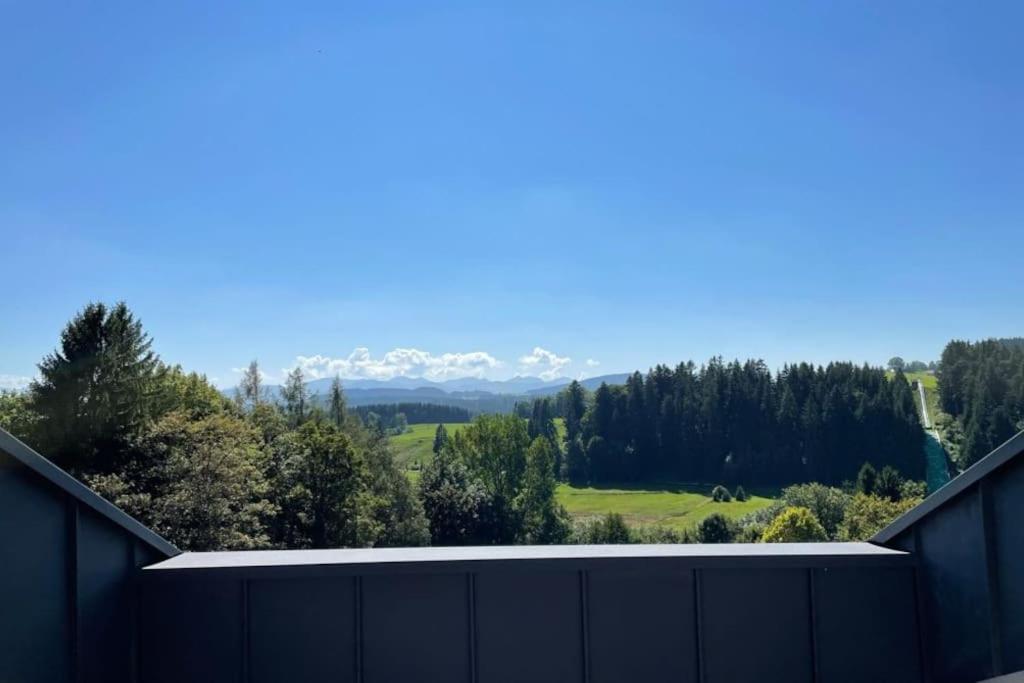 une vue depuis une clôture avec des montagnes en arrière-plan dans l'établissement Traumhafter Bergblick im Allgäuer Luftkurort, à Buchenberg
