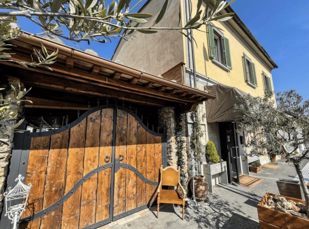 un cancello in legno per una casa con una sedia davanti di Locanda il Deserto a Livorno