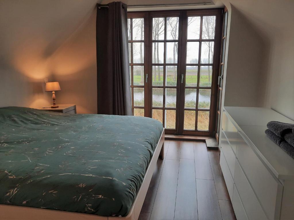 1 dormitorio con cama y ventana grande en Cosy & charming holiday house in Damme, en Damme