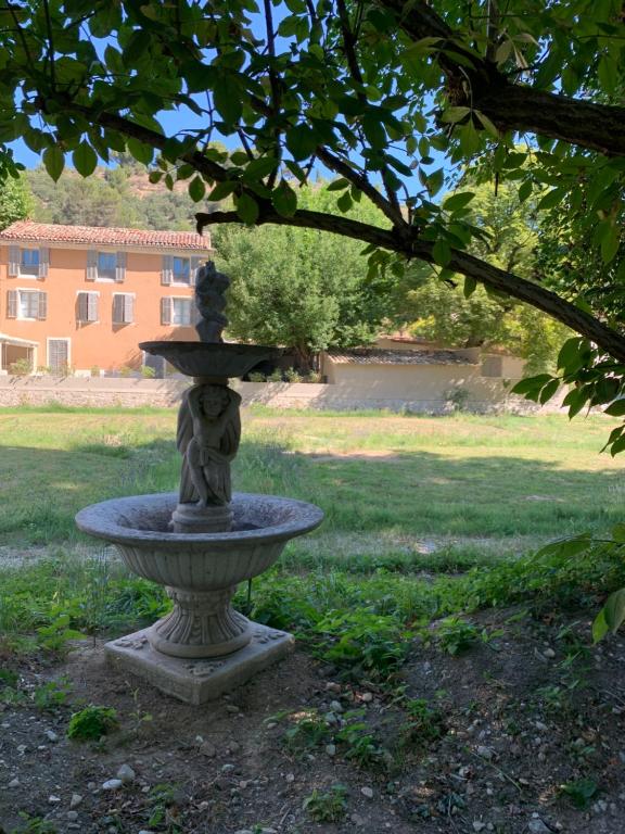 une fontaine en pierre au milieu d'un parc dans l'établissement Clos Augusta, à Riez
