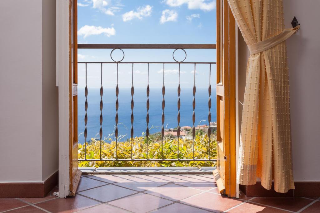 a room with a view of the ocean from a balcony at Antico Casale Ruoppo in SantʼAgata sui Due Golfi