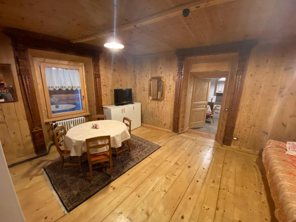 ein Esszimmer mit einem Tisch in einem Zimmer mit Holzwänden in der Unterkunft Appartamento Cavour in Bormio