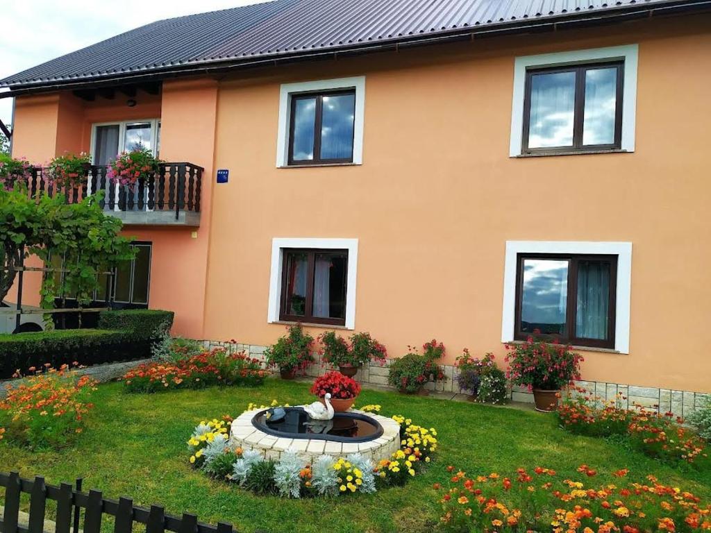 a house with a vase of flowers in the yard at Apartman Niki in Lič